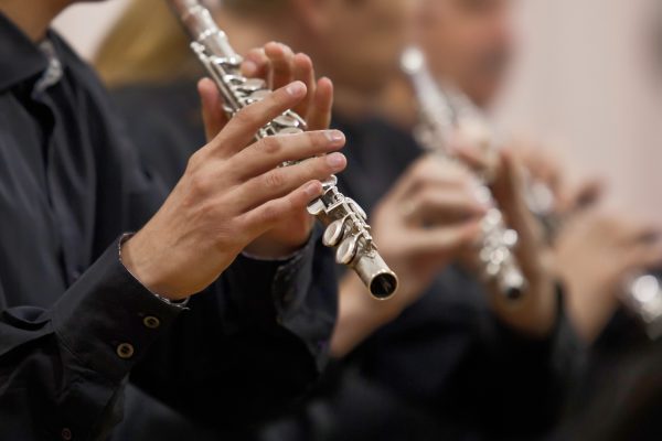 Hands musician playing the flute in the orchestra closeup